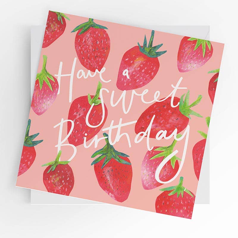 Pink square birthday greeting card with a repeat pattern of bright illustrated strawberries on a pink background and white script text reading "Have a Sweet Birthday."