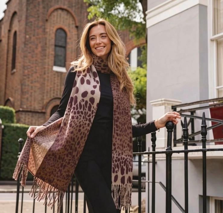 Oversized leopard print scarf in warm beige and camel tones with dark brown and burgundy spots and fringe tassel ends, shown as a gift from A Wee Token Belfast.