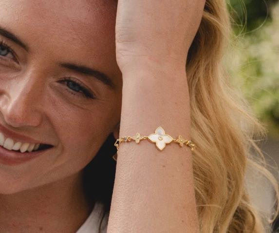 Model wearing 18K gold plated mother of pearl flower bracelet with cubic zirconia stones