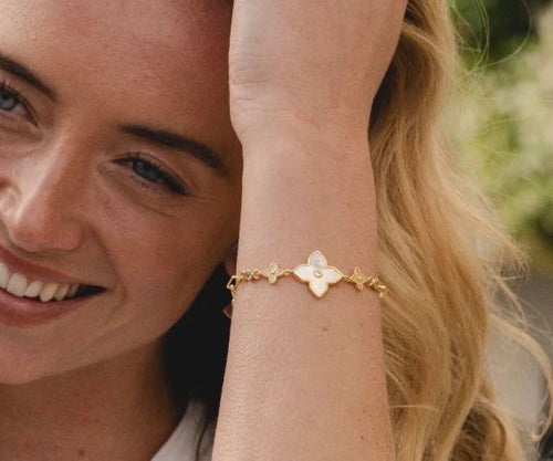 Model wearing 18K gold plated mother of pearl flower bracelet with cubic zirconia stones