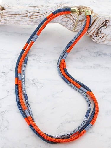 Long three strand cord necklace in orange, navy and grey with gold tone clasp and extender chain