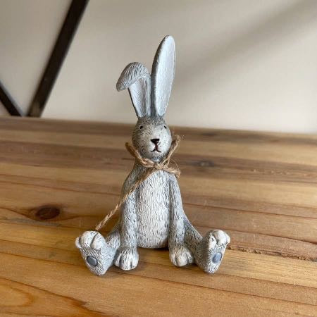 Rustic resin sitting bunny decoration in grey with twine bow—perfect for shelves, mantels and Easter displays. A cute Easter bunny ornament and gift idea.