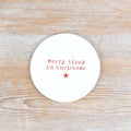 Round white ceramic coaster with the words Merry tipsy I'm Christmas in red lettering and a red star