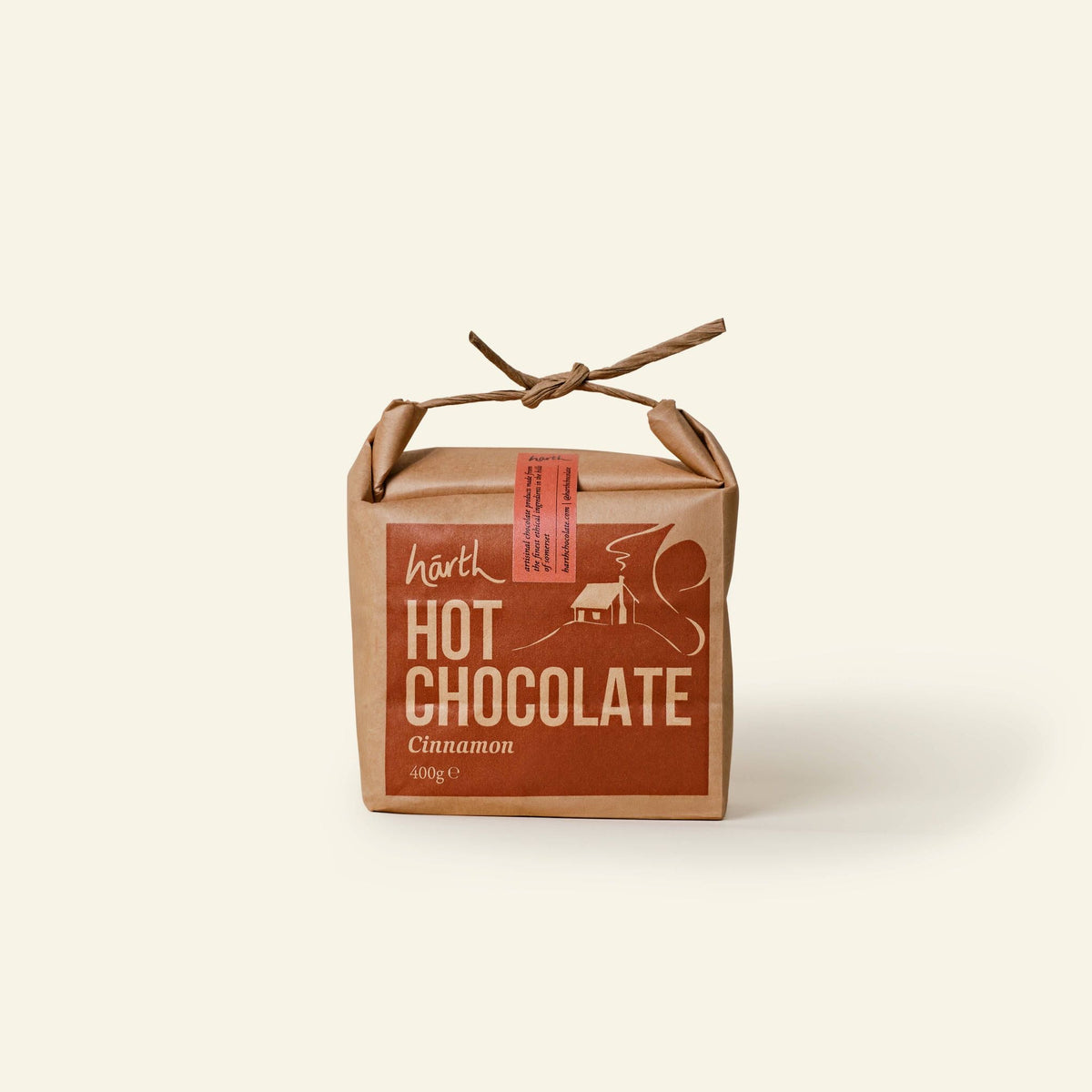 Harth Cinnamon Hot Chocolate 400g in brown paper packaging tied with string among autumn branches