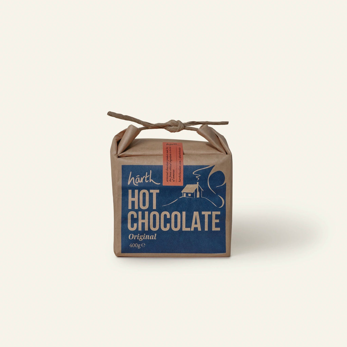 Harth Original Hot Chocolate 400g in brown paper packaging hanging on a silver birch tree