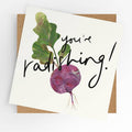 Square illustrated greeting card featuring a painted collage-style radish with green leaves on a white background and bold handwritten script reading "You're Radishing!," displayed with a kraft brown envelope.