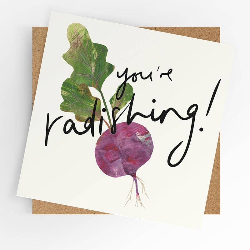 Square illustrated greeting card featuring a painted collage-style radish with green leaves on a white background and bold handwritten script reading "You're Radishing!," displayed with a kraft brown envelope.
