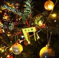 Handmade miniature yellow Harland and Wolff Samson and Goliath cranes decoration with red ribbon on a Christmas tree