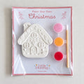 Paint Your Own Christmas craft kit with plaster gingerbread house, three paint pots and brush in a cellophane pack