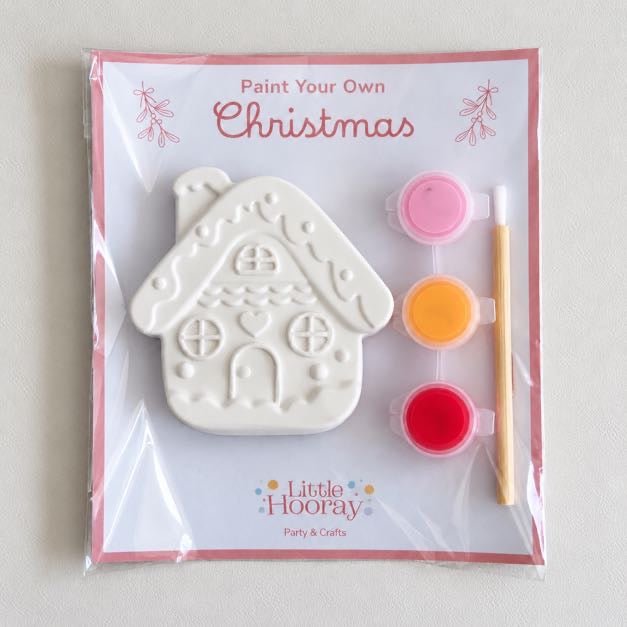 Paint Your Own Christmas craft kit with plaster gingerbread house, three paint pots and brush in a cellophane pack